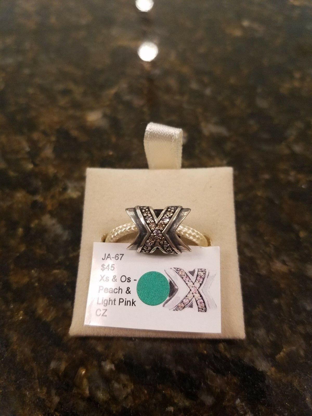 

Authentic Chamilia X s and O s- Peach and Light Pink CZ Charm