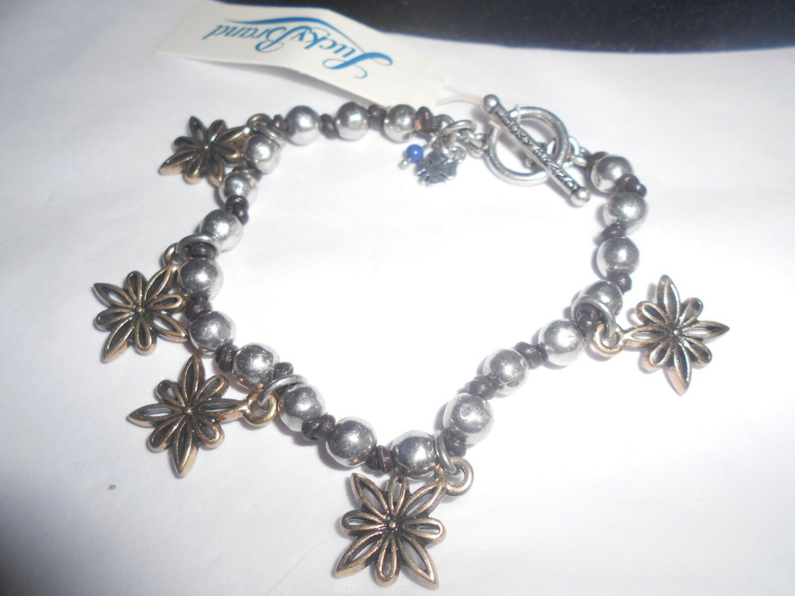 

LUCKY BRAND NWT SILVER TONE META LEATHER STRING FLOWERS CHARM BRACELET